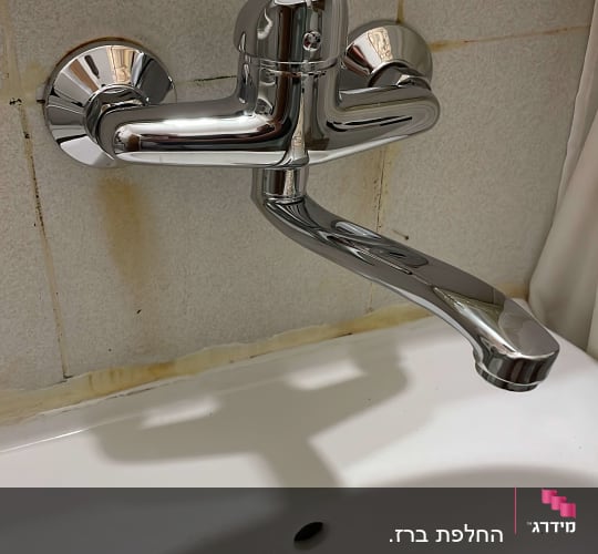 ברז כרום מותקן על קיר מעל כיור לבן